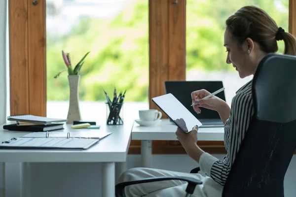 Attrayant entreprise asiatique femme à l'aide d'une tablette numérique tandis que assis dans un bureau de travail dans un bureau. — Photo