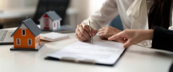 부동산 중개업자는 집을 매입하거나 판매하기 위한 고객 서명 계약서에 서명하도록 손을 제공 한다. 부동산 개념 접촉 협정 — 스톡 사진
