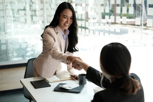 Giovani uomini d'affari asiatici stringono la mano in ufficio. Riunione conclusa con successo. — Foto Stock