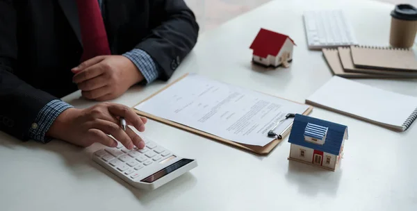 Empresário trabalhando fazendo finanças e custo de cálculo do investimento imobiliário, enquanto estar assinando contrato, Conceito de aprovação de empréstimo hipotecário — Fotografia de Stock