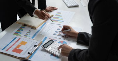 Finans, vergi, muhasebe, istatistik ve analitik araştırma konseptini hesaplamak için hesap makinesi ve dizüstü bilgisayar kullanarak iş adamı ve ortağını kapat