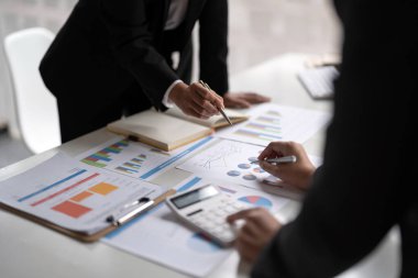 Finans, vergi, muhasebe, istatistik ve analitik araştırma konseptini hesaplamak için hesap makinesi ve dizüstü bilgisayar kullanarak iş adamı ve ortağını kapat