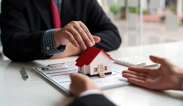 Fastighetsmäklare försäljningschef ger hus modell till kund efter att ha undertecknat hyresavtal försäljning köpavtal, om hypotekslån erbjudande för och husförsäkring. — Stockfoto