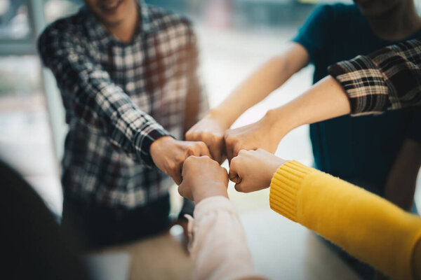 diverse group of asian business partner fist bump in modern office. Colleague partnership teamwork, university student, congratulation event, job or mission accomplish concept