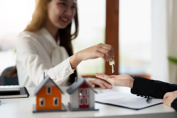 Immobilienmakler hält Hausschlüssel für seinen Mandanten nach Vertragsunterzeichnung im Büro, Konzept für Immobilien, Umzug oder Vermietung von Immobilien — Stockfoto