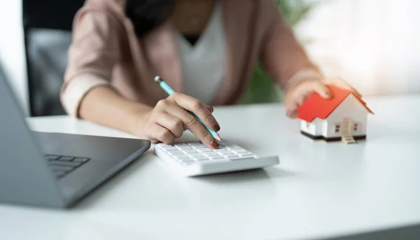 Main de femme d'affaires calculant les intérêts, les impôts et les bénéfices à investir dans l'immobilier et l'achat d'une maison — Photo