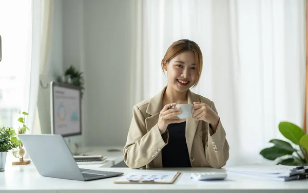 Genç ve güzel Asyalı iş kadını portresi kameraya bakıyor ve gülümsüyor, kollarını modern ofis işyerinde kavuşturuyor. — Stok fotoğraf