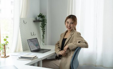 Asyalı kadın portresi İnternet 'te çalışıyor. Dizüstü bilgisayarda web yayınını izliyor. Eğitim kursu konferansını dinliyor..