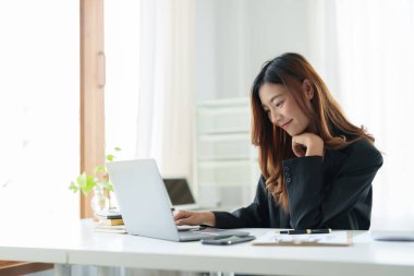 Portre Asyalı kadın çevrimiçi webinar ya da evde öğrenim için dizüstü bilgisayar kullanıyor.