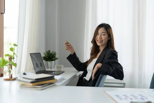 Ofiste dizüstü bilgisayarla çalışan Asyalı çekici bir iş kadını. Kameraya bakıyorum. — Stok fotoğraf