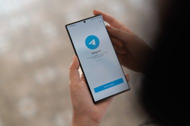 CHIANG MAI, THAILAND, APR 15, 2022: Samsung Galaxy s22 Ultra sosyal ağ servisi telgrafıyla el ele tutuşan kadın. Samsung şirketi tarafından yaratıldı ve geliştirildi.