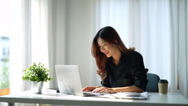 Vonzó okos ázsiai nő felnőtt segítségével laptop számítógép dolgozik online otthonról a nappaliban vidám frissesség kifejezés alkalmi boldogság életmód — Stock videók