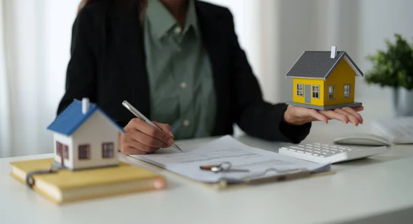 Agente imobiliário segurando modelo de casa para seu cliente depois de assinar contrato no escritório, conceito para imóveis, mudança de casa ou arrendamento de propriedade — Fotografia de Stock