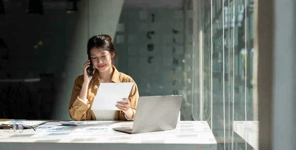 Jeune comptable asiatique appelant des consultants en marketing et utilisant un ordinateur portable pour analyser la croissance des ventes sur le marché mondial du travail. concept comptable — Photo