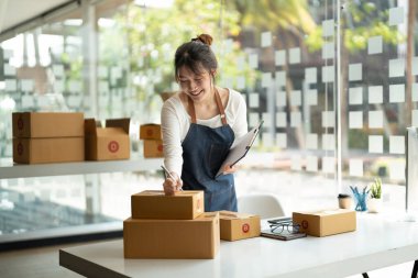 Genç Asyalı küçük işletme sahibi evde çalışma office, satınalma siparişlerinde not alma. Online Pazarlama ambalaj teslimat, başlangıç KOBİ girişimci veya serbest kadın kavramı