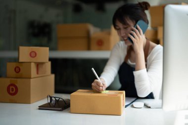 Genç Asyalı küçük işletme sahibi evde çalışma office, satınalma siparişlerinde not alma. Online Pazarlama ambalaj teslimat, başlangıç KOBİ girişimci veya serbest kadın kavramı