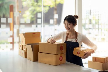 Genç Asyalı küçük işletme sahibi evde çalışma office, satınalma siparişlerinde not alma. Online Pazarlama ambalaj teslimat, başlangıç KOBİ girişimci veya serbest kadın kavramı