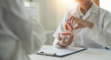 Diş sağlığı kliniğinde planlanan diş tedavisi hakkında dişçi ve hasta tartışması - dişçi danışmanlığı konsepti