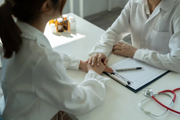 Beyaz üniformalı Asyalı kadın doktor özel hastanedeki kadın hastaya danışıyor. Kadın terapist, klinikte danışmanlık yaparken kadın müşteriyle konuşur. — Stok fotoğraf