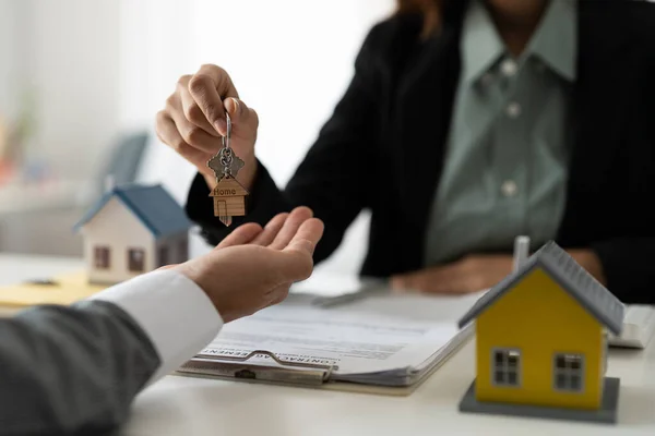 Immobilienmakler hält Hausschlüssel für seinen Mandanten nach Vertragsunterzeichnung im Büro, Konzept für Immobilien, Umzug oder Vermietung von Immobilien — Stockfoto