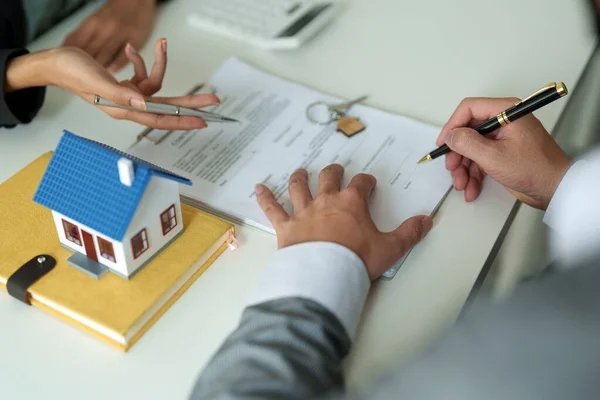 Fastighetsmäklare går med på att köpa ett hem och ge nycklar till kunder på deras agenturer. Begreppsavtal — Stockfoto