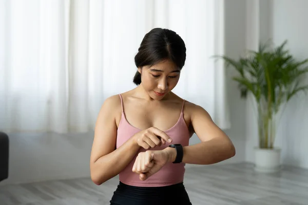 Mujer asiática la creación de la aptitud reloj inteligente para el entrenamiento de fitness en casa —  Fotos de Stock