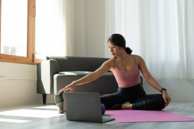 Genç kadın evde yoga egzersizi yapıyor. Fitness, egzersiz, sağlıklı yaşam ve diyet konsepti