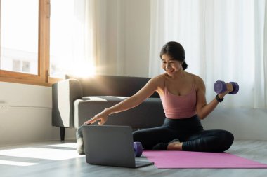 Genç kadın evde yoga egzersizi yapıyor. Fitness, egzersiz, sağlıklı yaşam ve diyet konsepti