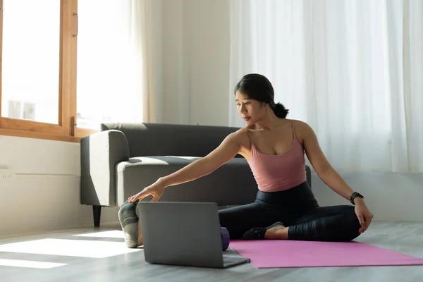 La joven está haciendo yoga en casa. Fitness, entrenamiento, vida sana y el concepto de dieta —  Fotos de Stock