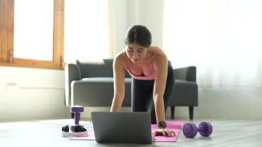 Asyalı kadın fitness eğitmeni bir video konferansında evde bir grup insanla sanal yoga dersi veriyor. Beden eğitimi hocası laptoptaki bir görüntülü konuşma üzerine online yoga dersleri alıyor.