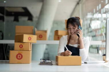 Genç Asyalı küçük işletme sahibi evde çalışma office, satınalma siparişlerinde not alma. Online Pazarlama ambalaj teslimat, başlangıç KOBİ girişimci veya serbest kadın kavramı