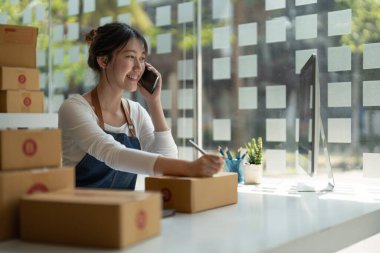 Genç Asyalı küçük işletme sahibi evde çalışma office, satınalma siparişlerinde not alma. Online Pazarlama ambalaj teslimat, başlangıç KOBİ girişimci veya serbest kadın kavramı