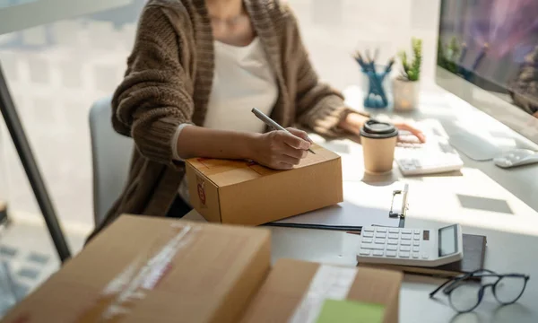Försäljning online affärskvinna ägare noterar kundens adress på paketet rutan förbereds för leverans — Stockfoto