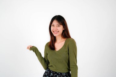 İzole edilmiş beyaz arka planda duran genç Asyalı kadın kameraya bakıp gülümsüyor. Pozitif kişi.