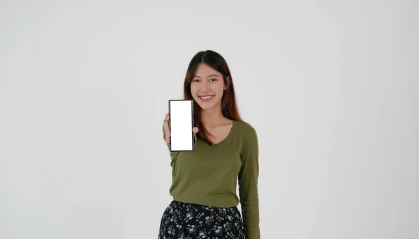Зображення молодої азіатки, що тримає смартфон, показує порожній білий екран на білому тлі . — стокове фото