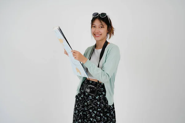 Мандрівник, який досліджує мрійливу азіатську жінку в капелюшній камері, тримає паперову карту під час екскурсії на білому тлі Пасажирські подорожі за кордон у вихідні дні — стокове фото