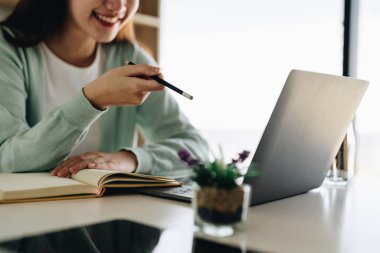 Kulaklık takıp Asyalı gial serbest çalışana konsantre ol. Bilgisayar aracılığıyla müşteriyle iletişim kur. Çevrimiçi dil dersi veren Milenyum güzeli profesyonel bayan öğretmen..