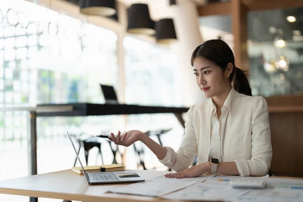 Attractive asian business woman working with a laptop and financial document at office, successful action, Business concept. — 스톡 사진