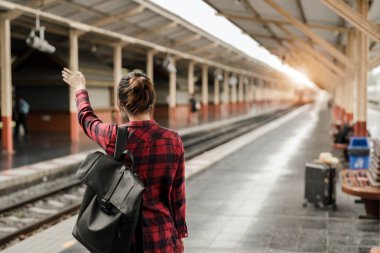 Genç Asyalı kadın backpacker gezgin yalnız tren istasyonu platformu sırt çantası ile yürüme. Tren seyahat tren istasyonunda bekleyen Asyalı kadın. Yaz tatili seyahat ya da genç turist kavramı