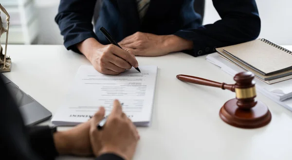 Empresário mão assinar após advogado prestação de serviços de consulta jurídica disputa no escritório com escala de justiça e martelo martelo — Fotografia de Stock