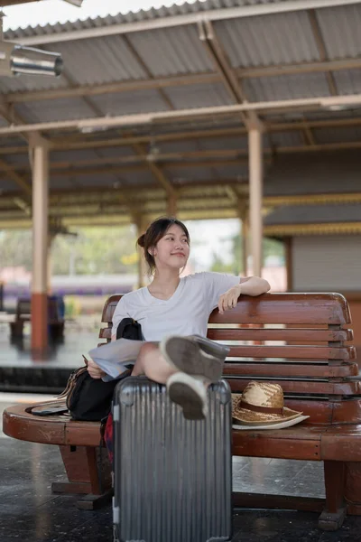 Jovem mulher asiática feliz viajante ou mochileiro usando mapa escolher onde viajar com bagagem na estação ferroviária, conceito de viagem de férias de verão — Fotografia de Stock