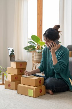 Girişimciler Küçük işletme KOBİ Bağımsız kadın evde çalışıyor. Ticari kontrol, çevrimiçi pazarlama, paketleme, KOBİ satıcıları, konsept, e-ticaret ekibi, çevrimiçi satış için akıllı telefonları kullanıyor.