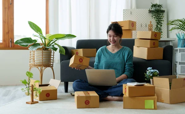 Küçük işletme girişimciliğine başlamak, yurt içinde çalışan Portre genç kadın, BOX, akıllı telefon, dizüstü bilgisayar, çevrimiçi, pazarlama, ambalaj, b2b, KME, e-ticaret kavramı