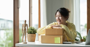 Portre girişimi küçük işletme KOBİ 'si, girişimin sahibi paket ürün kutusu hazırlamak için online alışveriş siparişini kontrol ediyor. Çevrimiçi fikirler satılıyor