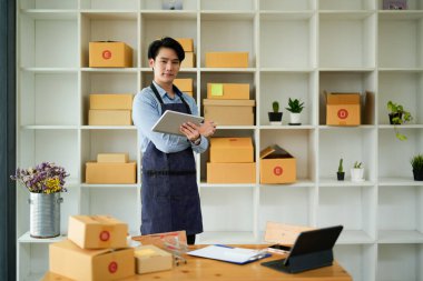 Başlangıçta küçük işletme KOBİ 'si, laptop kullanan girişimci paket ürün kutusu hazırlamak için online alışveriş siparişi alıyor ve kontrol ediyor. Çevrimiçi fikirler satılıyor