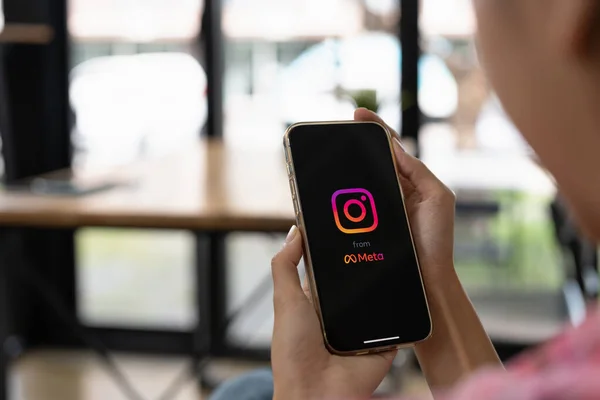 CHIANG MAI, TAILANDIA - 14 DE MAYO DE 2022: Mujer sosteniendo iPhone 13 Pro Max con aplicación de Instagram en la pantalla. Instagram es un popular servicio de redes sociales en línea — Foto de Stock