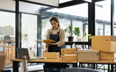 Başlangıçta KME küçük işletme girişimcisi KME ya da kutulu, çevrimiçi pazarlama paketleme kutusu ve teslimatı olan bir laptop kullanan serbest çalışan Asyalı kadın, KOBİ kavramı