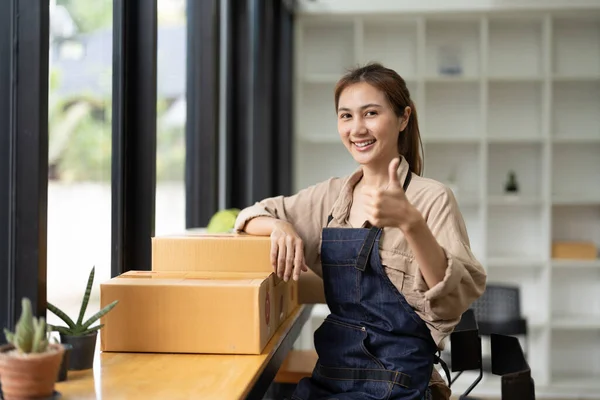 Starting a small business, SME owner, portrait female entrepreneur with products order online to prepare to pack a box of goods for sale to customers, sme business idea — Fotografia de Stock