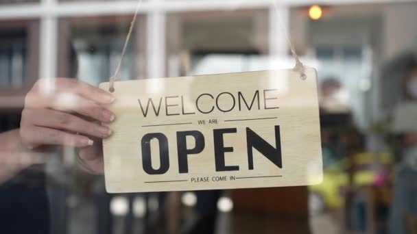 Small business owner concept cafe owner turning the sign from open to close sign after lockdown. slow motion. — Vídeo de Stock