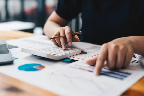 Close-up van zakenvrouw of accountant hand holding pen werken aan rekenmachine voor de berekening van bedrijfsgegevens, boekhoudkundig document en laptop computer op kantoor, business concept — Stockfoto